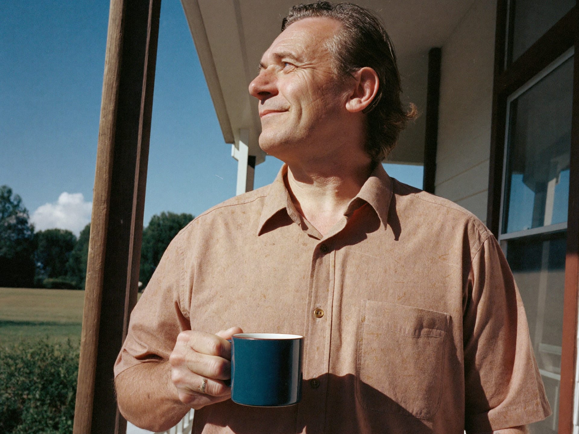 A man enjoying a clear, bright morning on his porch