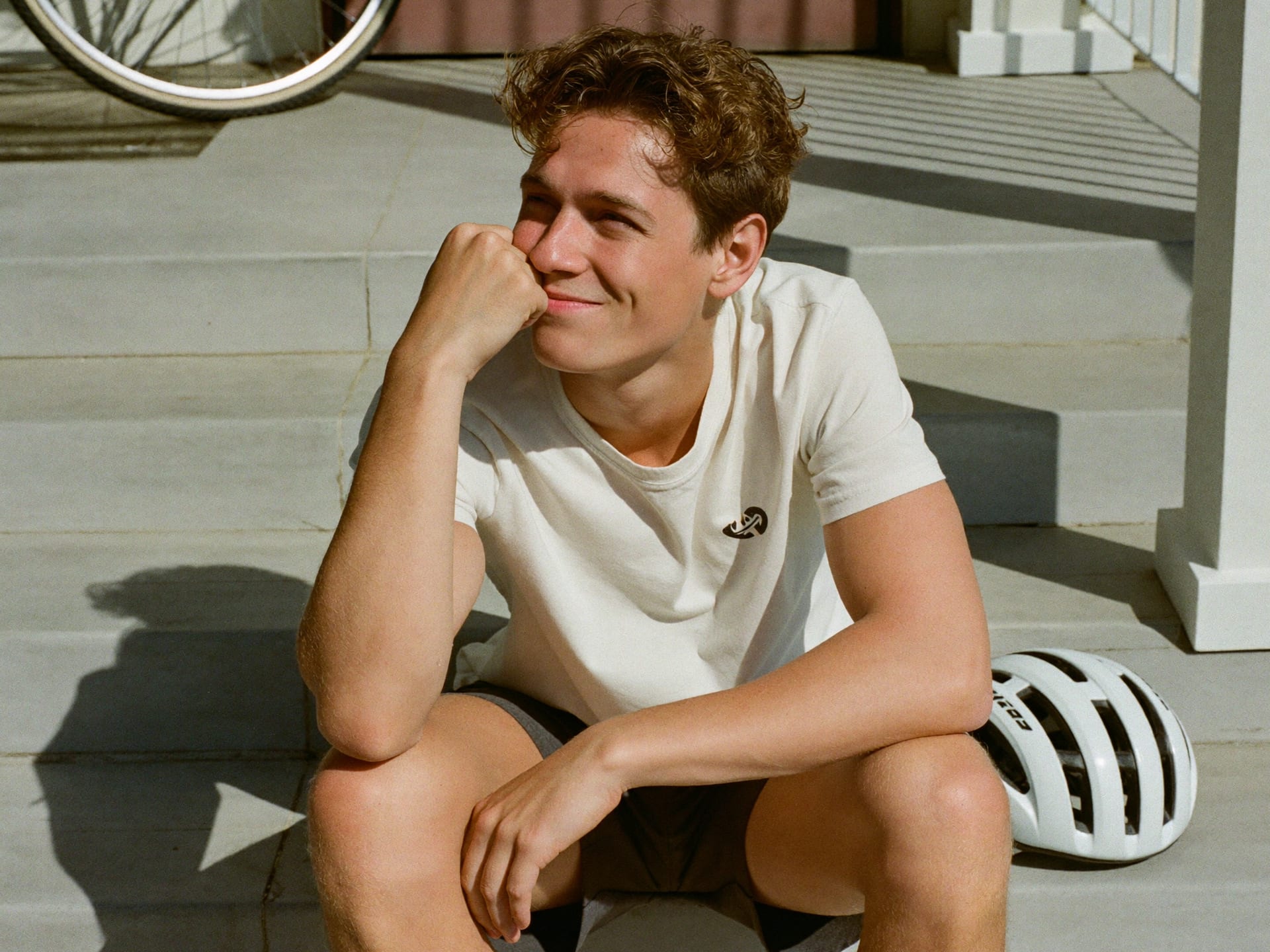 A young man feeling clear-headed and calm on his porch steps