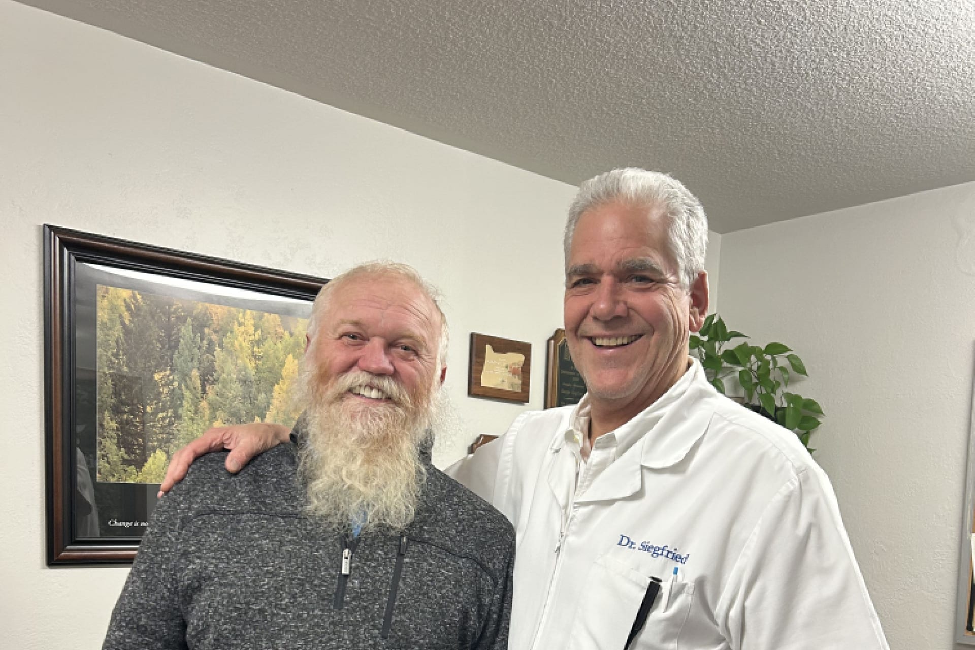 Dr. Siegfried smiling with longtime patient Fred Anfilofief at the clinic